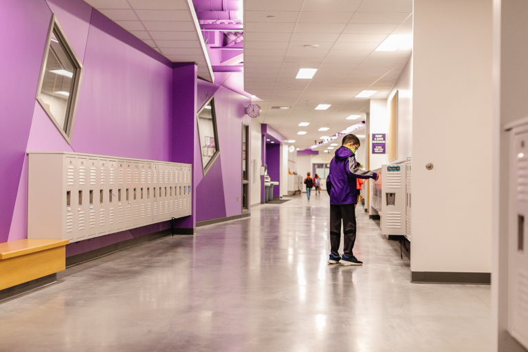 Corridor painted purple with lockers and child