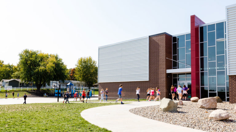 Exterior with playground and students entering building