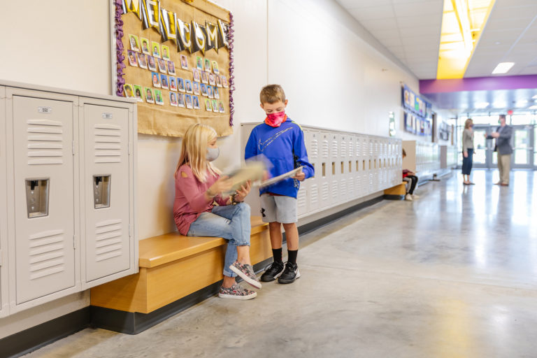 Corridor with students reading on a bench