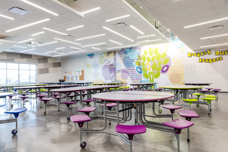 Lunchroom with tables and a mural