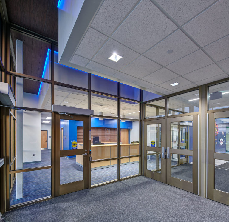 Looking into reception area from entrance vestibule with blue accent lighting