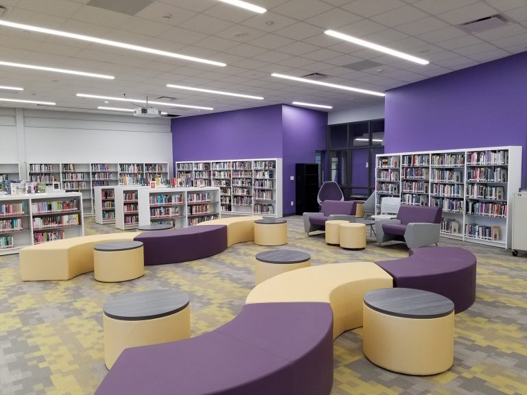 Media center with soft seating and purple accent wall