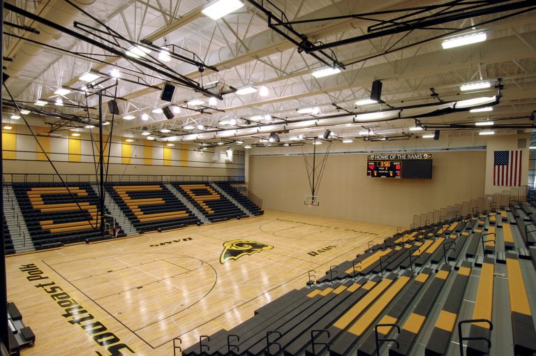 Gymnasium with exposed structure and lettering on bleachers