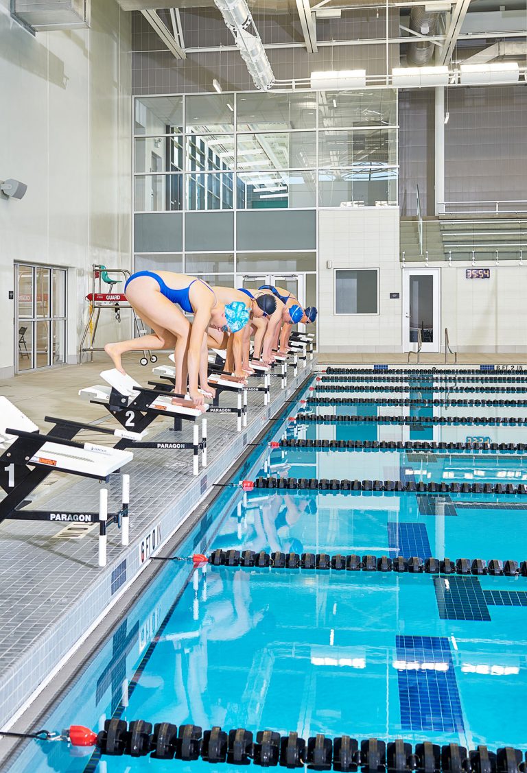 Swimmers preparing to dive in pool