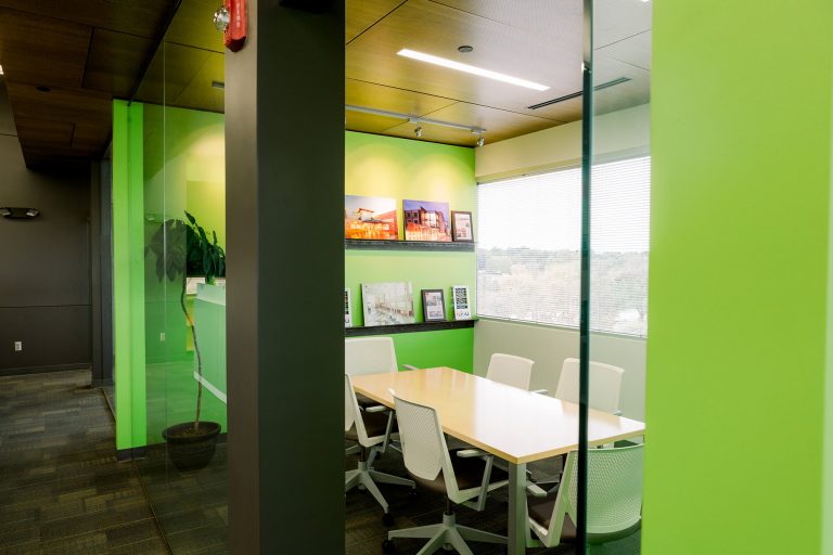 Conference room with green accent walls and awards