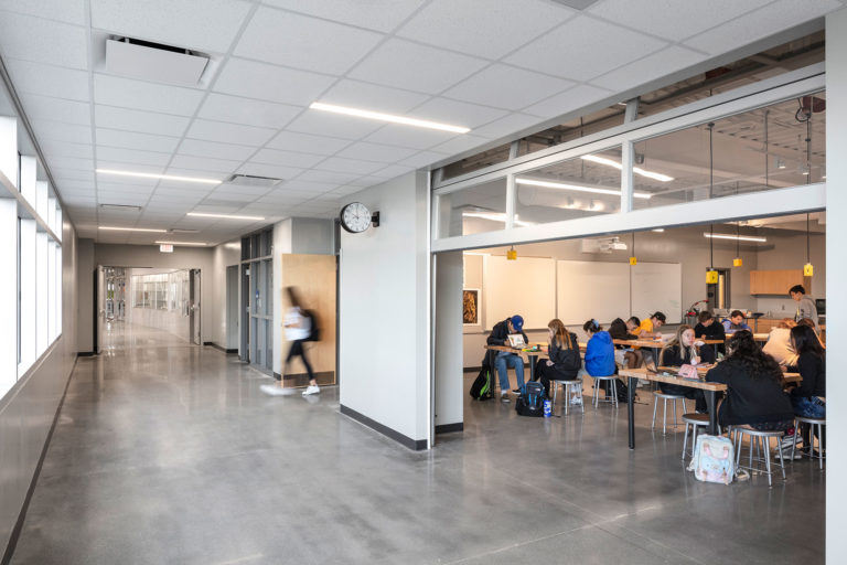 Art classroom with garage doors opening to light filled corridor