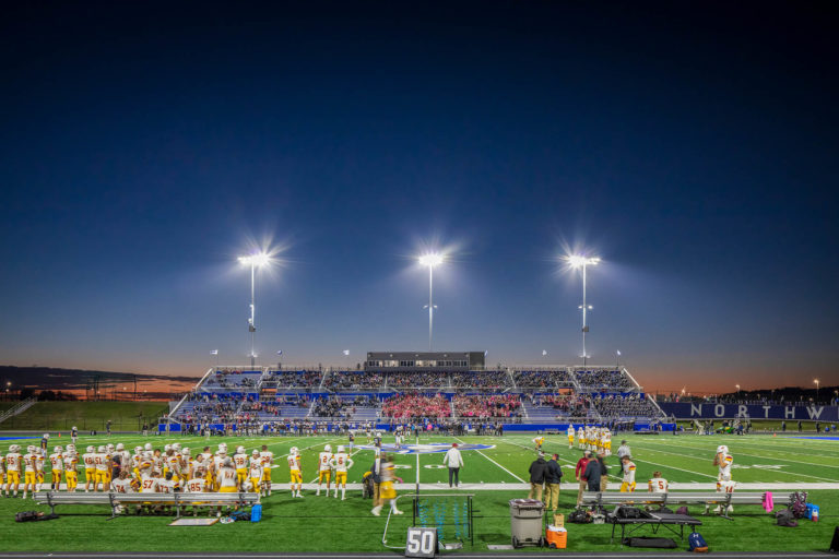 Dusk view of stadium from football field looking at bleachers