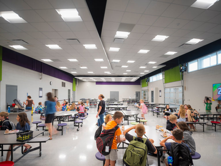 Cafeteria with students at tables and angled ceilings