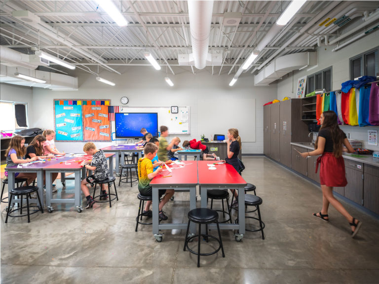 Art room with concrete floors and colored tables