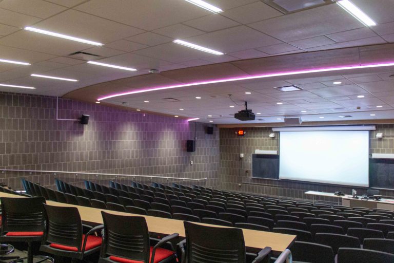 College lecture hall looking down at presentation from back of room